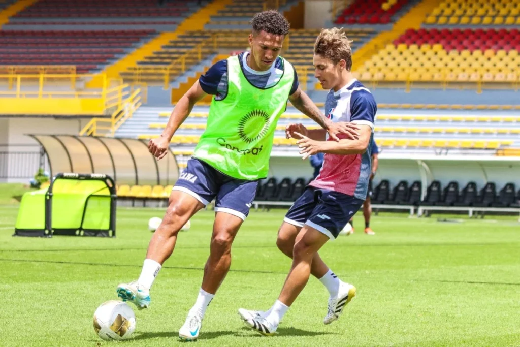 Jean Carlos López, capitán de la Selección Nacional de Fútbol maneja la pelota ante la marca de Lucas Bretón, dos jugadores que salieron de la Liga Dominicana de Fútbol